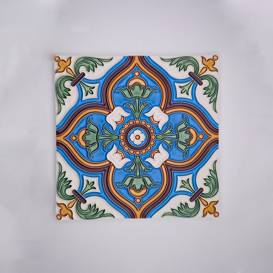 A vibrant hand-painted decorative porcelain tile from Tejo Shop with a symmetrical design featuring a central green and orange motif surrounded by blue, green, and white decorative patterns, set on a white background.