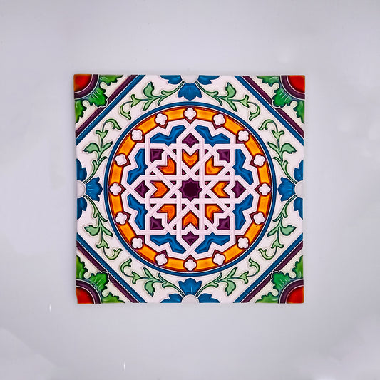 A colorful hand-painted Tejo Shop ceramic tile featuring intricate geometric and floral patterns in shades of blue, green, red, and orange on a white background.