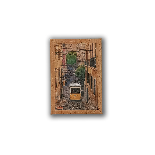 The New Jamp "Bica Lift - Cork Fridge Magnet" features a yellow Lisbon tram on a steep, narrow street with buildings and greenery, framed by a textured cork border, capturing the charming spirit of Portugal.