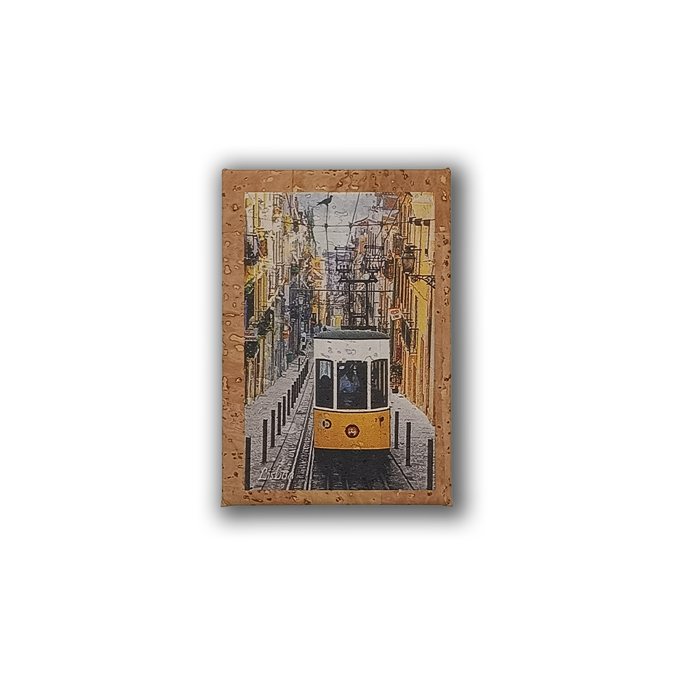 The Bica - Cork Fridge Magnet by New Jamp captures a yellow tram climbing a steep, narrow Lisbon street with colorful buildings and overhead wires, seen through a rain-speckled window—an iconic city souvenir.