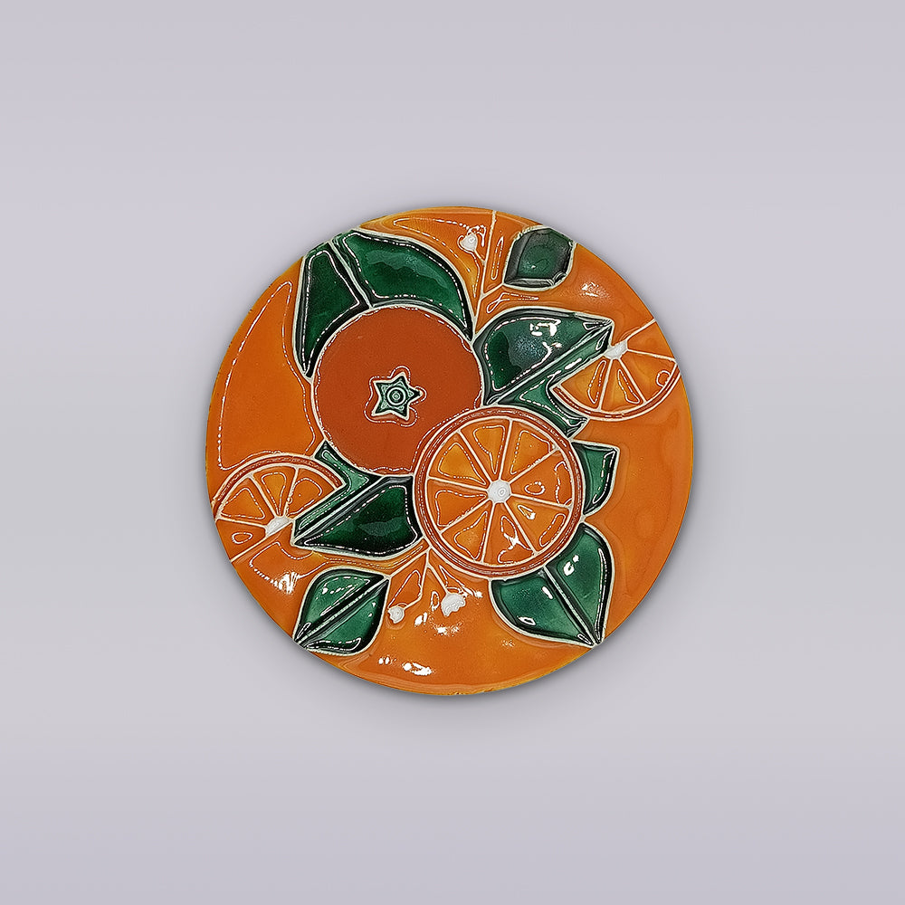 The Algarve Orange Blossom Ceramic Coaster by Miradouro Ceramics features an overhead view of vibrant oranges, slices, and green leaves on an orange background, set against a light gray surface.