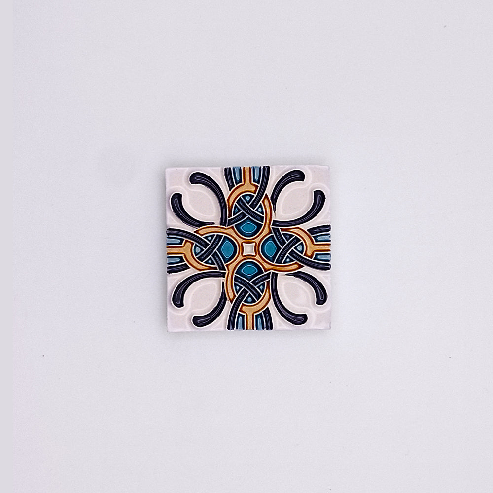 A Tejo Shop hand-painted ceramic tile with a symmetrical geometric pattern, featuring intricate blue, black, and orange designs on a white background. The pattern includes both curved and angular elements, ideal to elevate your