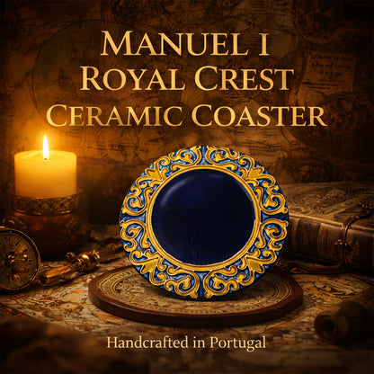 A decorative Manuel I Royal Crest Ceramic Coaster by Miradouro Ceramics, featuring ornate blue and yellow patterns, is displayed upright. A lit candle, compass, and old books sit nearby. Handcrafted in Portugal.