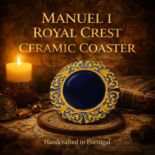 A decorative Manuel I Royal Crest Ceramic Coaster by Miradouro Ceramics, featuring ornate blue and yellow patterns, is displayed upright. A lit candle, compass, and old books sit nearby. Handcrafted in Portugal.