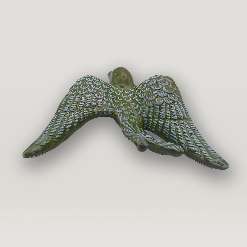 A green Tejo Shop Portuguese Ceramic Swallow with wings on a white background.