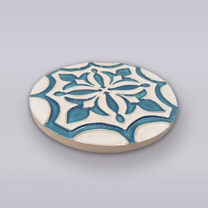 The Portuguese Flor-de-Lis Tile – Atlantic Edition by Miradouro Ceramics features a raised blue and white floral-cross motif on ceramic—a charming decorative accent displayed against a light gray background.