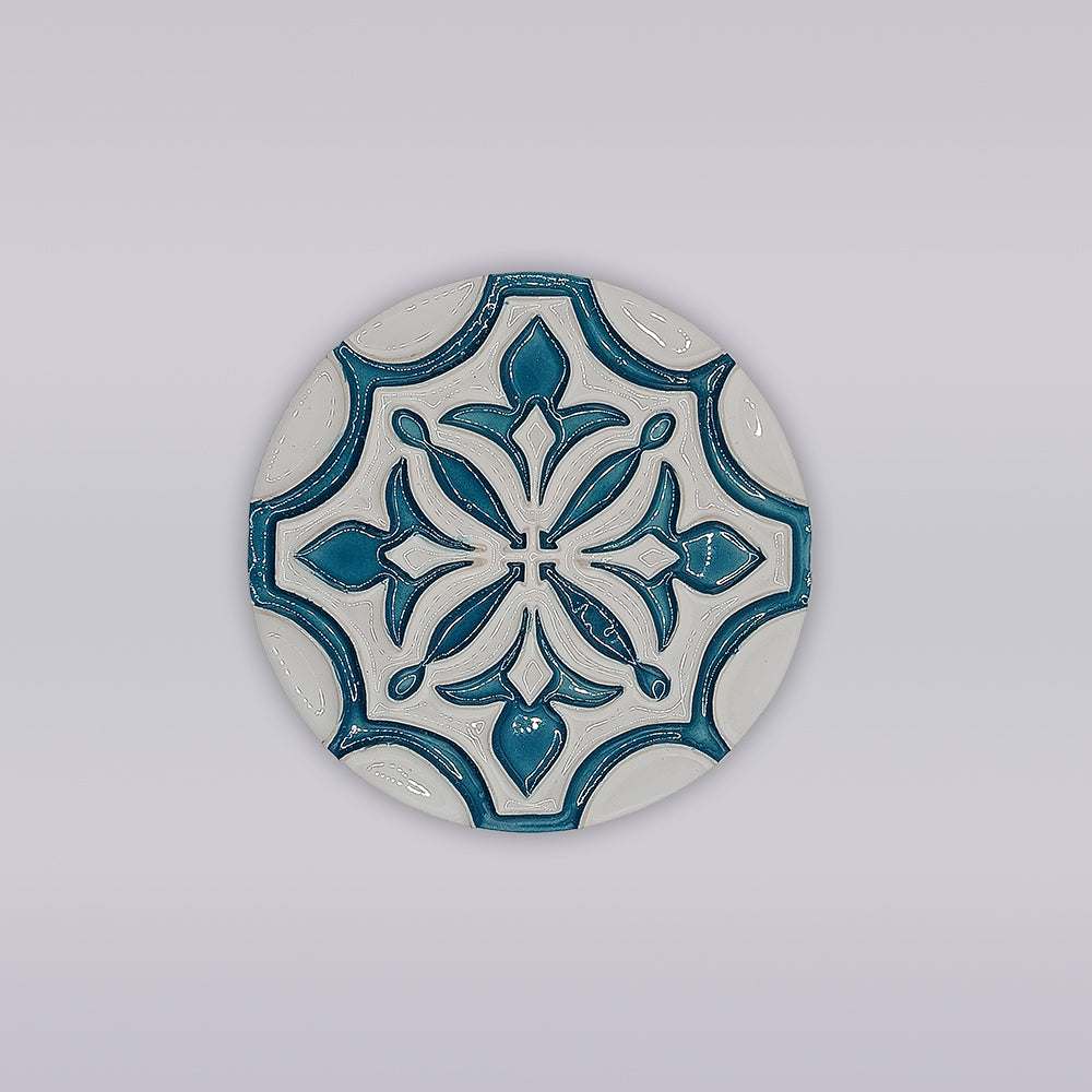 The Miradouro Ceramics Portuguese Flor-de-Lis Tile – Atlantic Edition is a round ceramic accent featuring a blue and white floral-cross motif on light gray, ideal for decorative use.