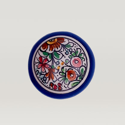 Decorative ceramic plate with hand-painted floral design on a white background from Tejo Shop featuring the XVII Century Wine bottle stopper.