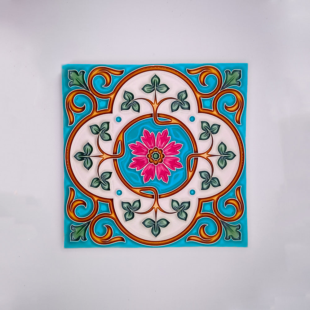 A colorful hand-crafted ceramic tile with a decorative pattern featuring a pink floral design at the center surrounded by green leaves and blue and orange swirls on a white background from Tejo Shop's Hand Made Painted Tile.