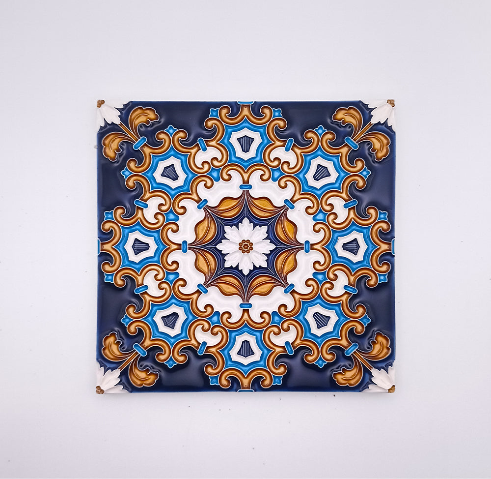 Decorative Drop Ceiling Tiles by Tejo Shop, hand painted with a symmetrical pattern featuring blue, gold, and white colors, hung on a white wall with visible nails at each corner.