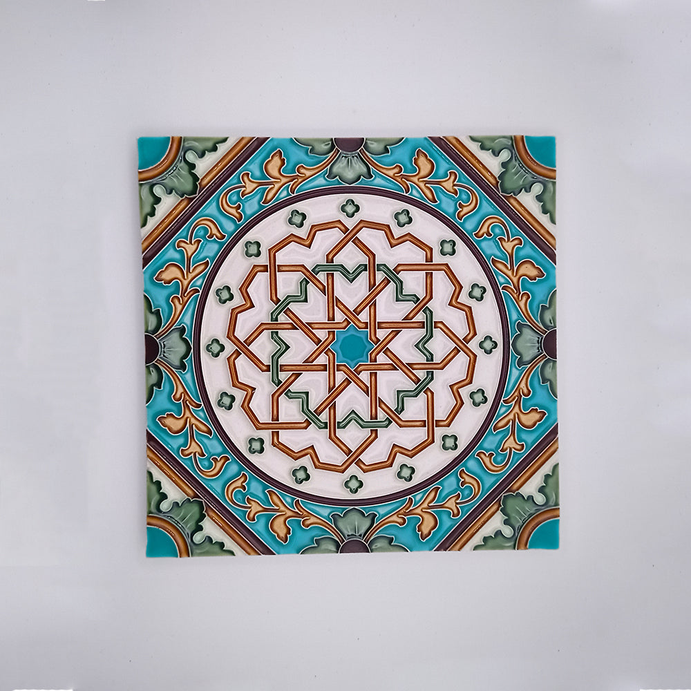 A Moorish Decorative Tile by Tejo Shop featuring a hand-painted symmetrical geometric and floral pattern in shades of green, turquoise, orange, and white, displayed against a plain light background.