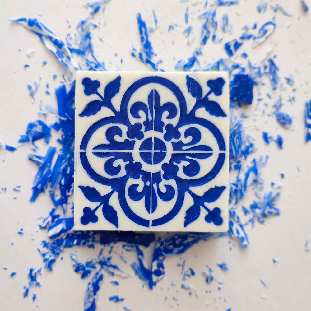 The Lisbão Amêndoa Royale Tile Soap Bar is a square, handcrafted soap featuring an intricate blue floral and geometric pattern on white, evoking Portuguese tile design and offering a delicate marzipan scent.