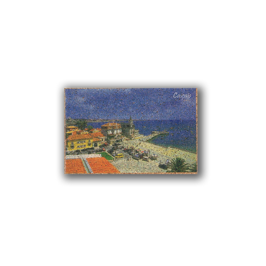 The Cascais - Cork Fridge Magnet by New Jamp features a postcard-style image of Estoril Beach’s sandy shores, vibrant buildings, and church tower—an eco-friendly souvenir from Portugal.