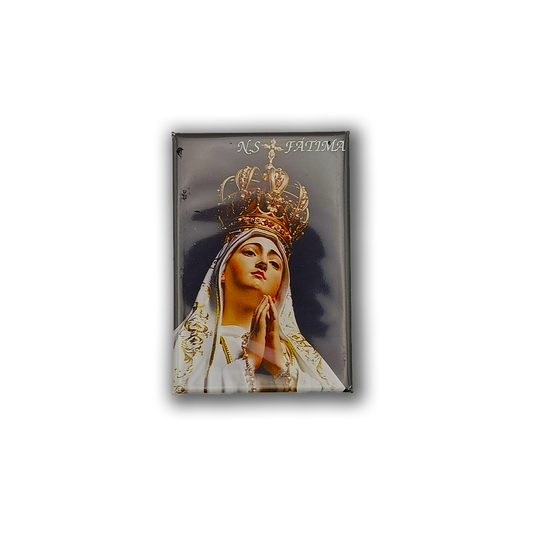 The New Jamp Our Lady of Fatima - Fridge Magnet features a crowned figure in white robes, hands clasped in prayer, with "N.S. FATIMA" at the top right against a dark background—a perfect Lisbon souvenir.