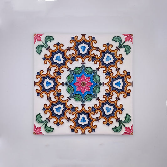 A square Tejo Shop Belém Painted Ceramic Tile featuring a symmetrical pattern with stylized floral and geometric shapes in vibrant colors of blue, orange, green, and pink on a white background.